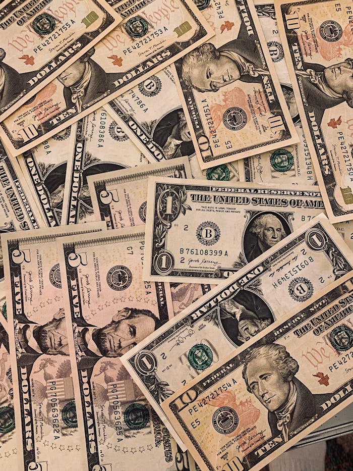 A collection of various US dollar banknotes arranged in an overlapping pattern.